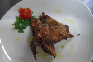 Piatto di quaglia arrosto con pomodoro e prezzemolo.