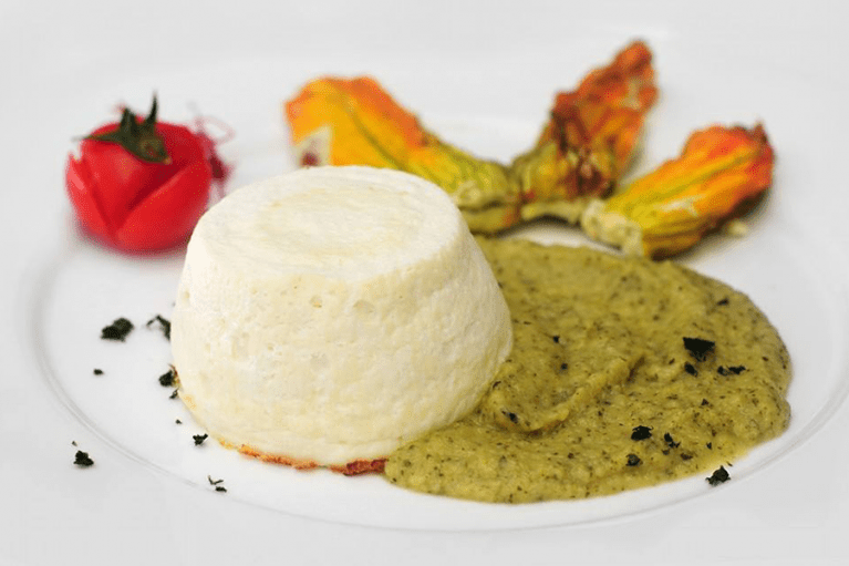 Sformato bianco con crema verde e fiori di zucca.