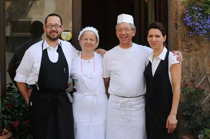 Quattro persone in abiti da lavoro davanti a un edificio.