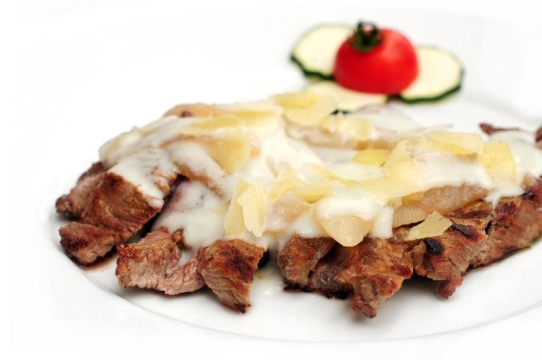 Bistecca con formaggio fuso, pomodoro e zucchine.