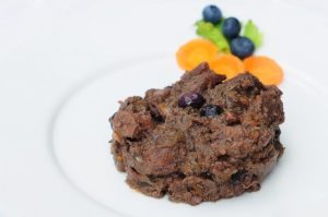 Piatto di carne con mirtilli e carote.