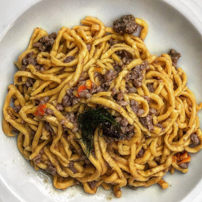 Piatto di pasta con ragù di carne e verdure.