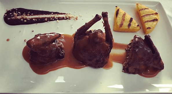 Tre porzioni di carne con salsa e polenta grigliata.