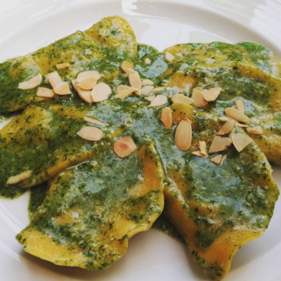 Ravioli al pesto con scaglie di mandorle.